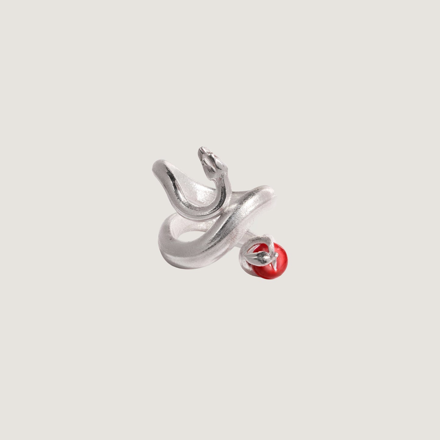 Silver snake with a red apple on a light gray background