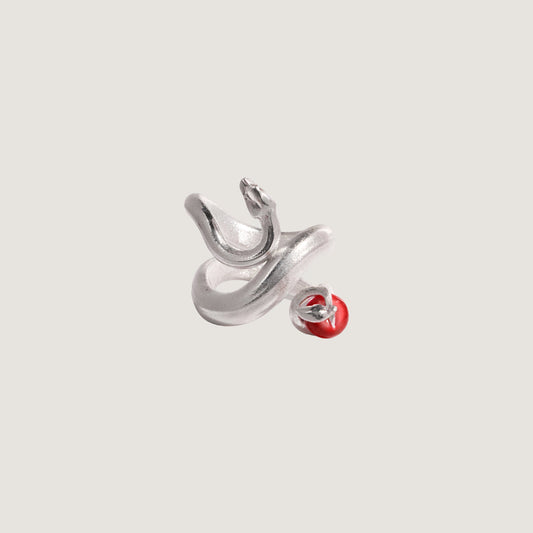 Silver snake with a red apple on a light gray background